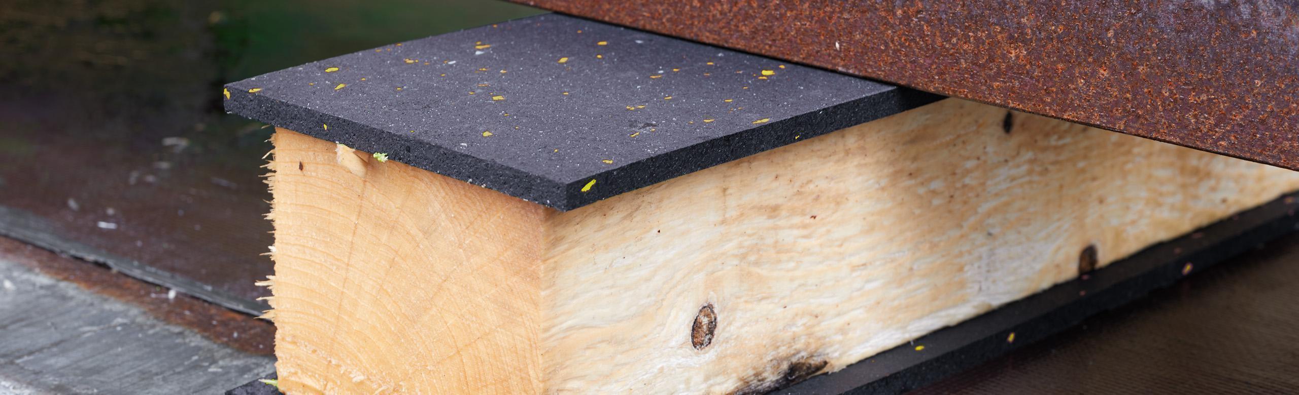 Antirutschmatte zur Ladungssicherung auf einem Kantholz verklebt auf dem ein Stahlträger gelagert ist REGUPOL Antirutschmatten im Einsatz